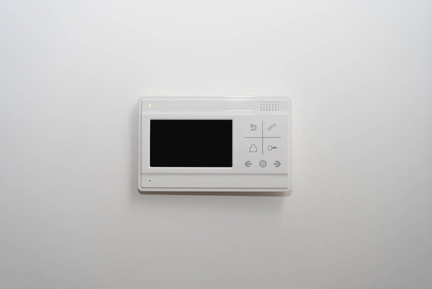 video intercom on a white wall near the entrance door to the apartment - Photo, Image