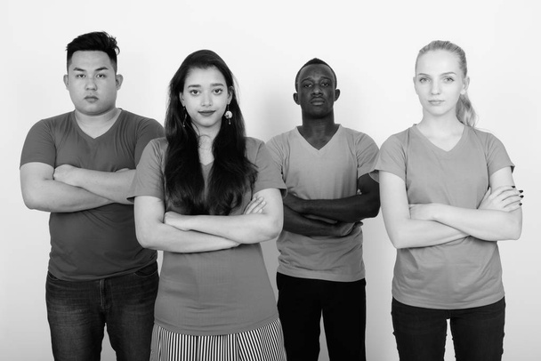 Estudio de un grupo diverso de amigos multiétnicos con los brazos cruzados juntos
 - Foto, Imagen