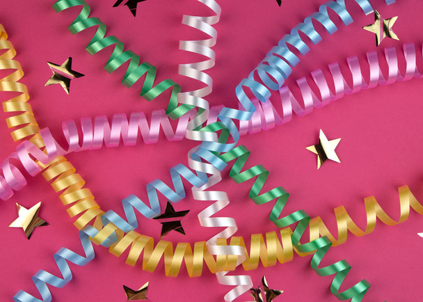 Pembe arka planda karnaval şenlikli kıvrımlı renkli kağıt şeritleri - Fotoğraf, Görsel