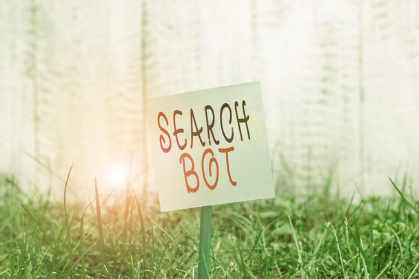 Znak tekstowy pokazujący Search Bot. Conceptual photo program, który uruchamia zautomatyzowane zadania przez Internet lub sieć Zwykły pusty papier przymocowany do patyka i umieszczony w zielonej trawiastej ziemi. - Zdjęcie, obraz