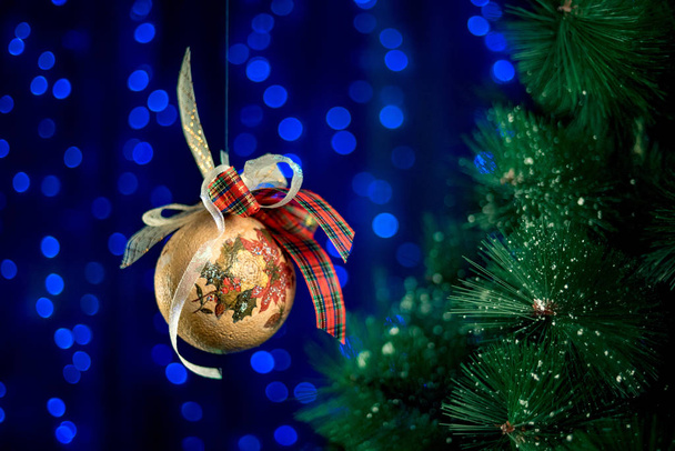 bola de Navidad vintage casera rodando en el aire cerca de árbol de Año Nuevo
.  - Foto, imagen