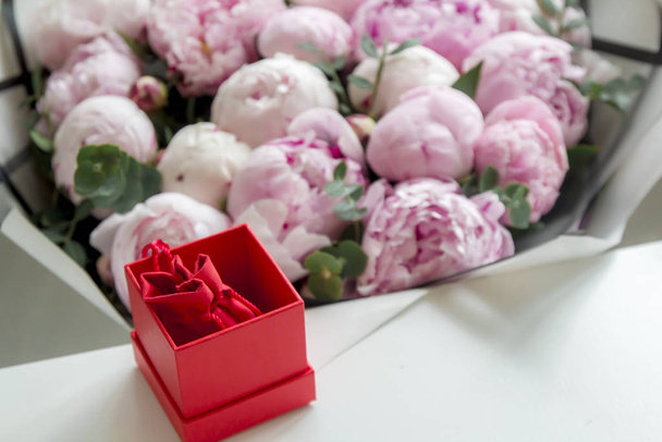 close-up of pink peony flowers and red gift box  - Foto, afbeelding