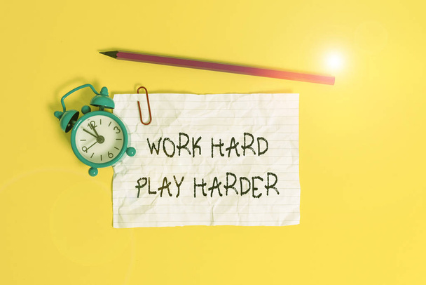 Conceptual hand writing showing Work Hard Play Harder. Business photo showcasing a Balance Life Have a Break Destressing to Relax Metal alarm clock ccrushed sheet pencil colored background. - Photo, Image