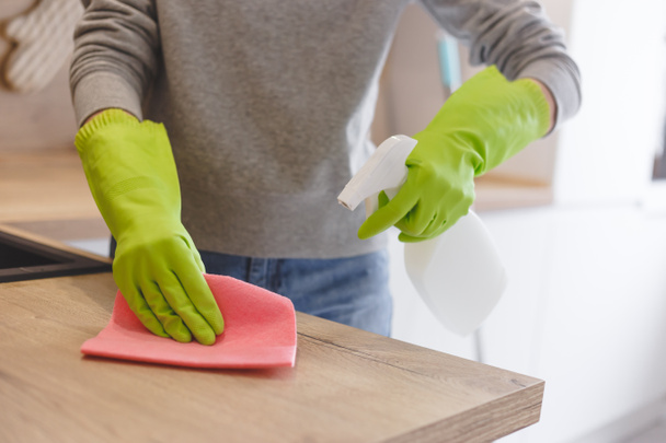 Nahaufnahme Frau putzt Küche mit Reinigungsspray und Tuch. - Foto, Bild