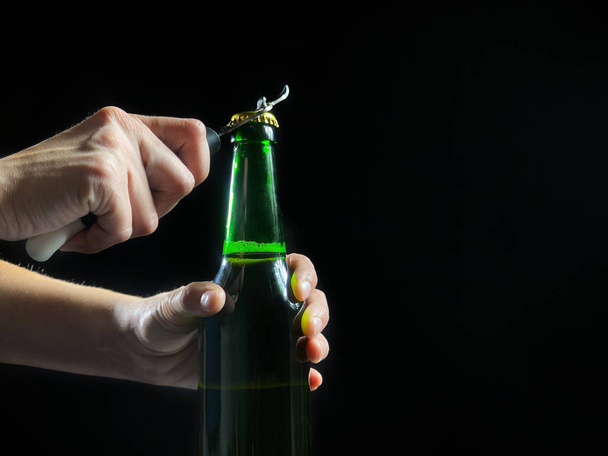 Womans hands is opening green bottle of beer, slow motion video - Photo, Image
