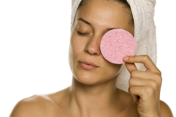 young beautiful woman posing with a sponge pad on the white background - Photo, image