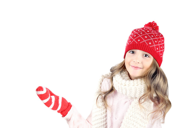 Child girl in christmas hat and glowes showing empty space isola - Foto, Imagen