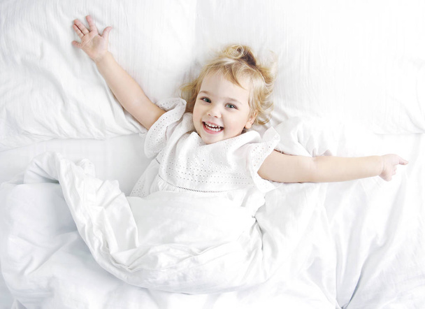 Cacasian baby child in a bed, happy morning healthy kid lifestyl - Foto, afbeelding
