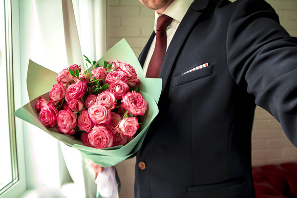 man holding a bouquet of roses - Фото, изображение