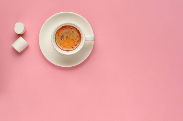 kreative flache Lage aus weißer Kaffeetasse und zwei Marshmallows auf tausendjährigem rosa Hintergrund. Minimaler Stil. Kopierraum, Overhead, Draufsicht. Mockup für feminine Blogs, soziale Medien, Netzwerke - Foto, Bild