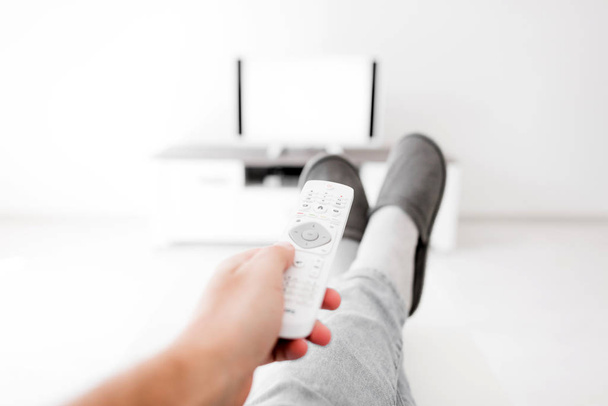 Hombre mirando TV con piernas en la mesa en la sala de estar
. - Foto, imagen