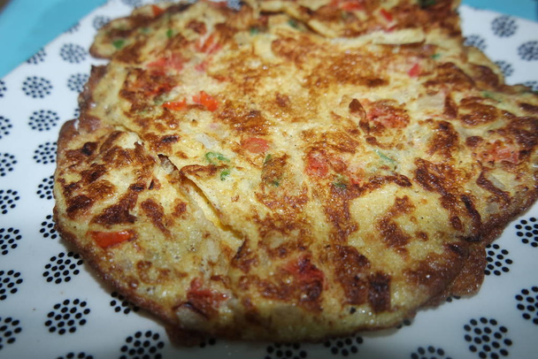 Close-up viewof egg omelet with peppers and spices sprinkled - 写真・画像