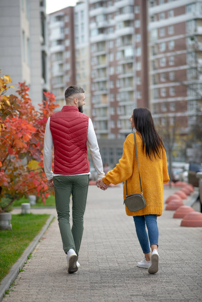 Pleasant young couple enjoying their autumn walk - Фото, изображение