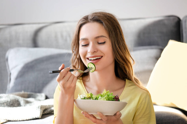 自宅で健康的な野菜サラダを食べる女性 - 写真・画像