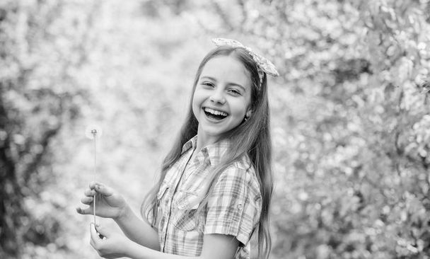 Summertime fun. Folklore beliefs about dandelion. Girl rustic style making wish and blowing dandelion nature background. Why people wish on dandelions. Celebrating summer. Dandelion full symbolism - Foto, Bild