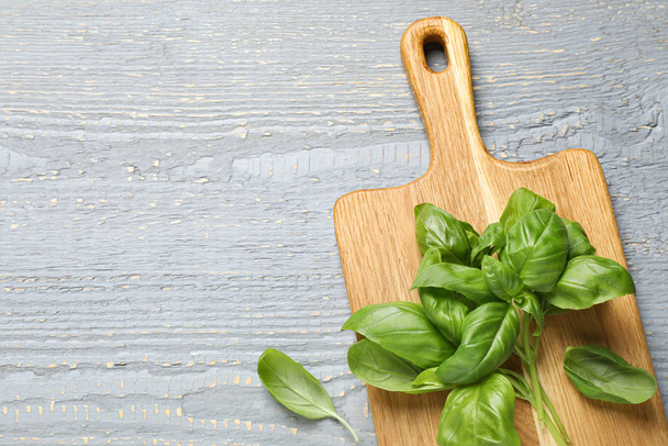 Fresh green basil on light grey wooden table, above view. Space for text - Photo, image