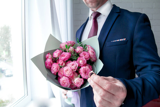 man holding a bouquet of roses - Φωτογραφία, εικόνα