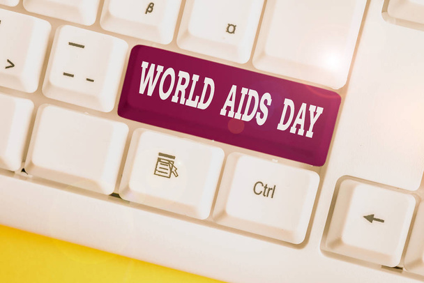 Word writing text world aids day. Geschäftskonzept für den 1. Dezember zur Sensibilisierung für die Hilfsmittel weiße PC-Tastatur mit leerem Notizpapier über weißem Hintergrund Schlüsselkopierraum gewidmet. - Foto, Bild