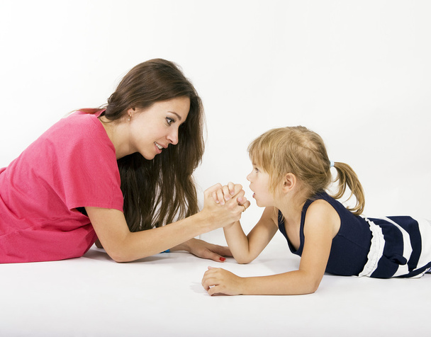mother and daughter arm wrestling (difficult parenting) - Фото, изображение