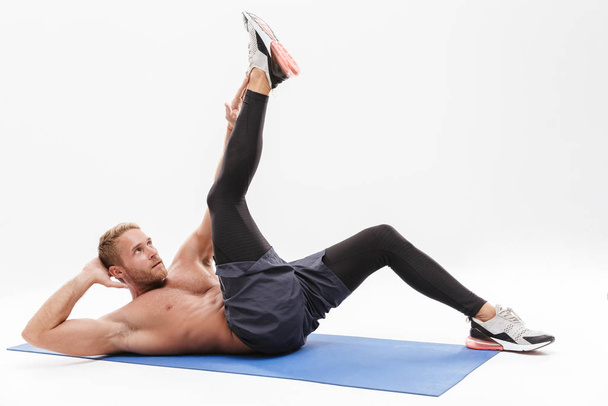Confident attractive sportsman doing core exercise - Zdjęcie, obraz