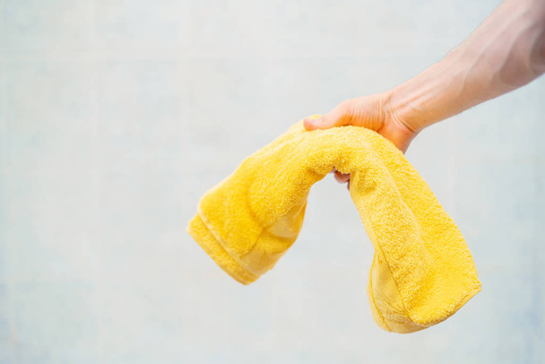 person hand holding a color towel before taking a bath - Photo, Image