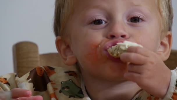 Adorable niño de dos años comiendo pan y queso
 - Metraje, vídeo