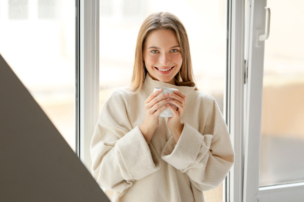 giovane donna con tazza di tè caldo a riposo a casa - Foto, immagini