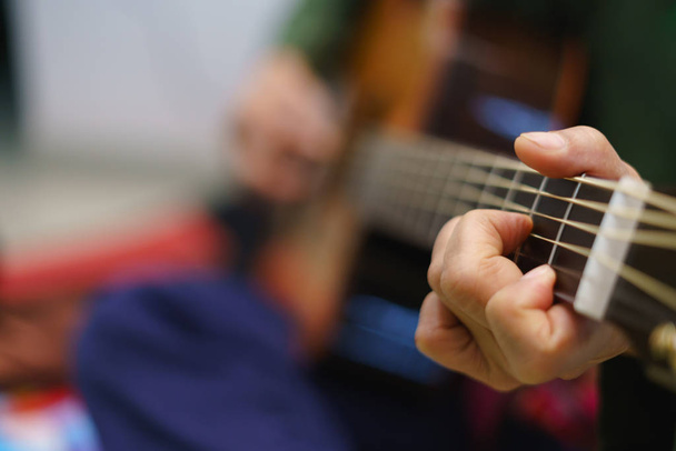 Ακουστική κιθάρα παίζει με την άκρη δακτύλου - Φωτογραφία, εικόνα