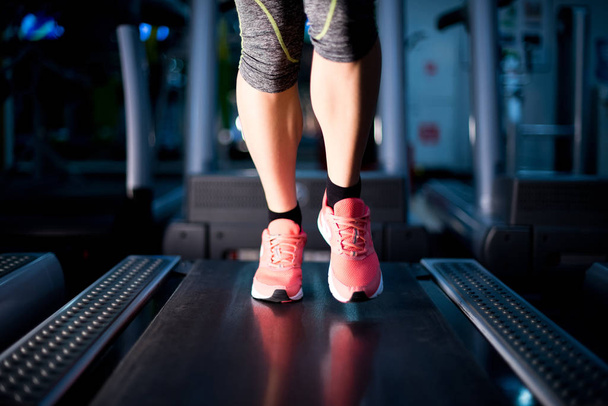 legs of a girl running on a treadmill - Фото, изображение
