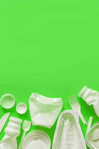 Used white plastic packaging for food on a lime green background - Fotó, kép