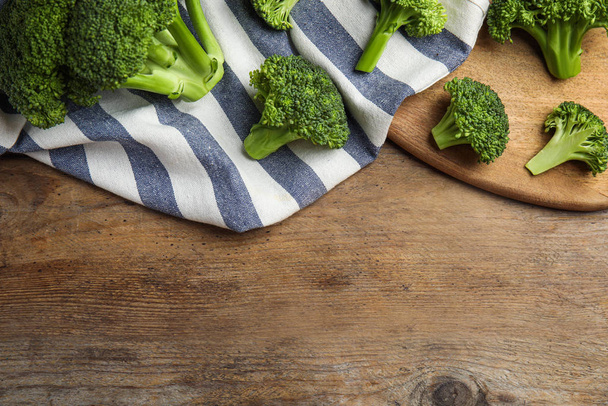 Fresh green broccoli on wooden table, flat lay. Space for text - Zdjęcie, obraz
