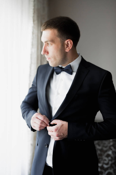 Grooms morning preparation. Handsome man getting dressed and preparing for the wedding - Foto, Bild