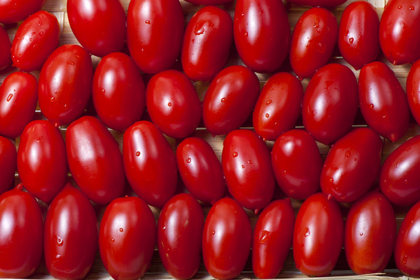 Pequeños tomates rojos maduros oblongos
 - Foto, Imagen