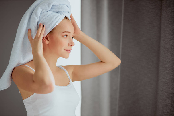 Woman with towel on head is relaxing after shower - Foto, imagen