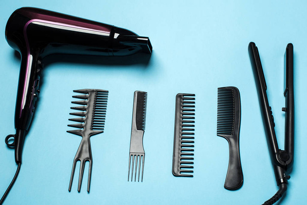 pentes e ferramentas de cabeleireiro na vista superior de fundo azul
 - Foto, Imagem