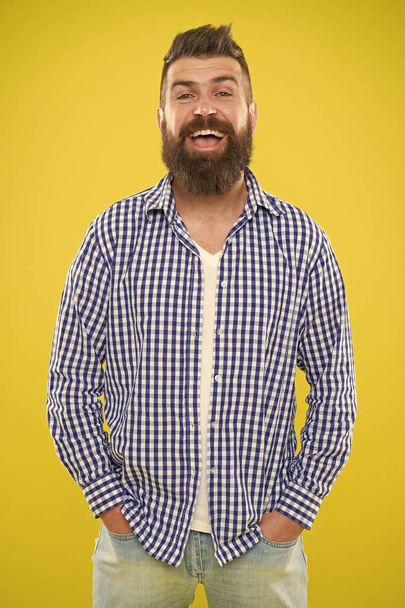 Brutal bearded hipster in checkered shirt. Male fashion and spring style. Mature happy man hipster. Summer hipster. Emotional man with beard on yellow background. hipster fashion look of smiling man - Photo, image