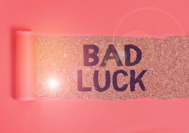 Text sign showing Bad Luck. Conceptual photo an unfortunate state resulting from unfavorable outcomes Mischance Cardboard which is torn in the middle placed above a wooden classic table. - Photo, Image