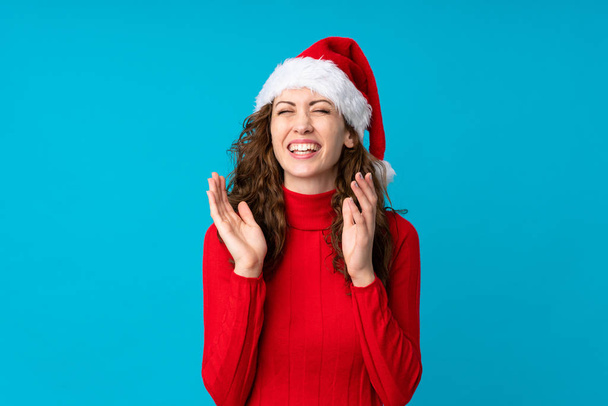 Mädchen mit Weihnachtsmütze über gelbem Hintergrund lacht - Foto, Bild