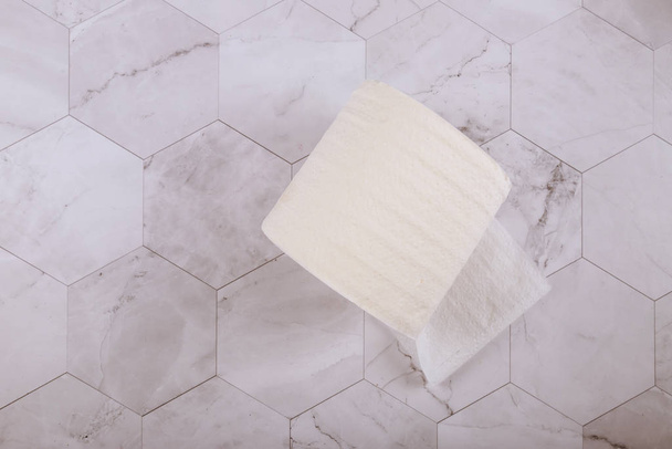 Biała rolka miękkiego papieru toaletowego na białych płytkach w łazience - Zdjęcie, obraz