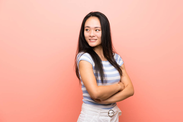 adolescente asiatico ragazza oltre isolato rosa sfondo con braccia incrociate e felice
 - Foto, immagini