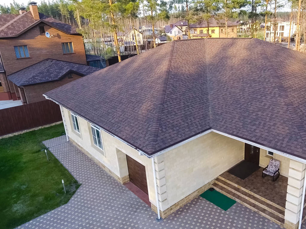 Tuile bitumineuse pour un toit. Maison avec un toit d'un bitumineux
 - Photo, image