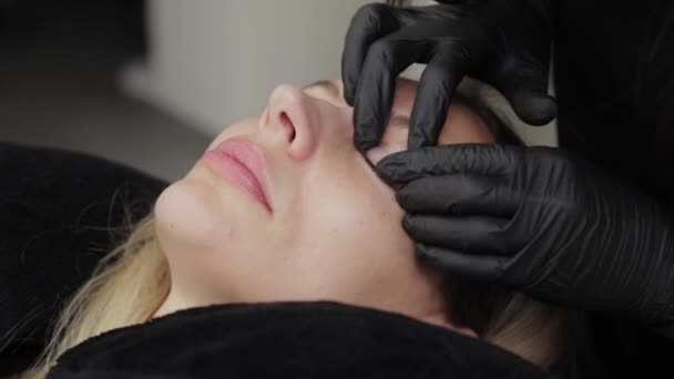 professionelle Kosmetikerin in einem Schönheitssalon klebt Silikonfutter für Wimpernkaschierung. - Filmmaterial, Video
