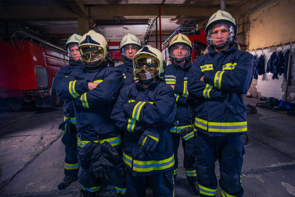Retrato de bomberos de grupo frente al camión de bomberos dentro del interior del interior.  - Foto, imagen