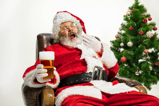 Santa Claus drinking beer near Christmas tree, congratulating of New Year 2020 - Zdjęcie, obraz