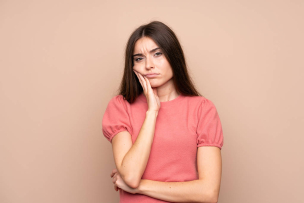 Young woman over isolated background unhappy and frustrated - Photo, Image