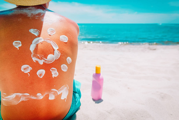 zonnebescherming-kind met zonnebrandcrème op tropisch strand - Foto, afbeelding