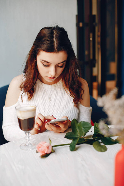 A girl with the rose and dessert in cafe - Фото, изображение