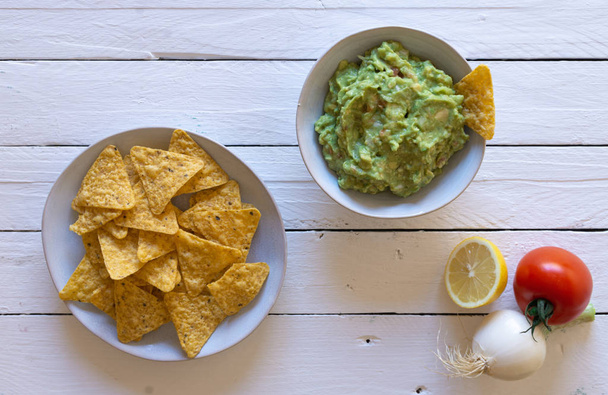 Guacamole nachos and guacamole ingredients, zenith view - Photo, Image
