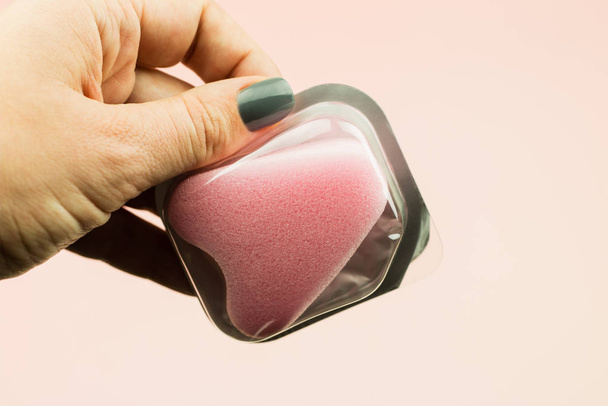 Close up de mão mulher segurando tampão esponja menstrual em packag
 - Foto, Imagem
