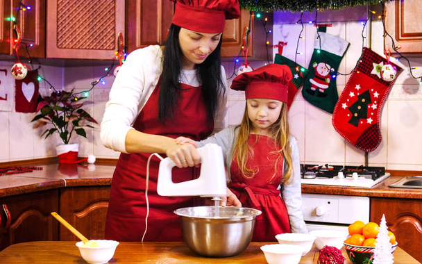 Mãe ensina sua filha misturando ingredientes com misturador elétrico . - Foto, Imagem